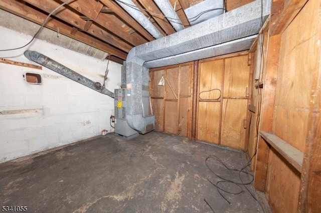 unfinished basement featuring heating unit