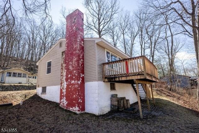 view of side of property featuring stairway and a wooden deck