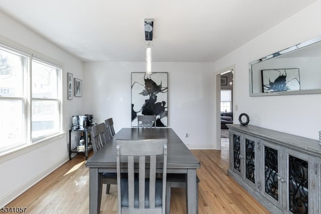 dining area with light wood-style floors and baseboards