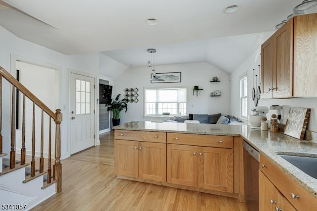 kitchen with a peninsula, plenty of natural light, stainless steel dishwasher, and lofted ceiling