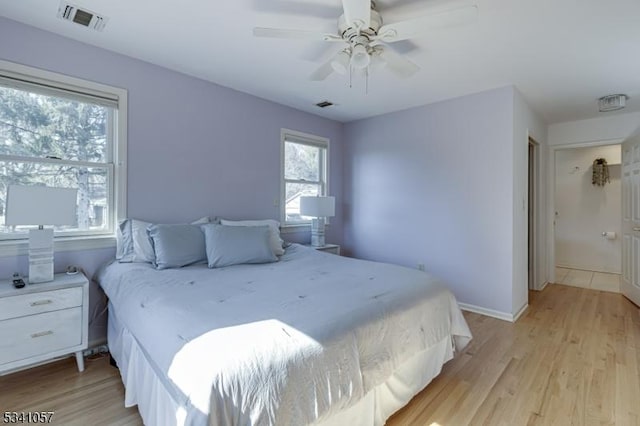 bedroom featuring visible vents, light wood-style flooring, and baseboards