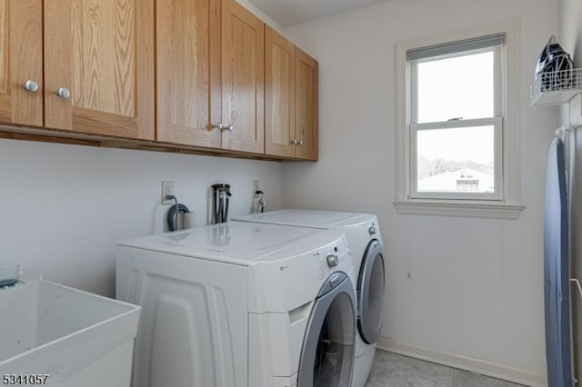 laundry room with washing machine and dryer, cabinet space, a sink, and baseboards