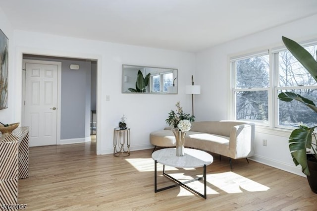 living area with light wood-style floors and baseboards