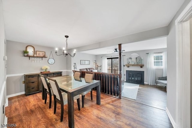 dining room with plenty of natural light, wood finished floors, and a glass covered fireplace