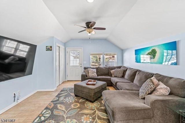 living area with a ceiling fan, vaulted ceiling, baseboards, and wood finished floors