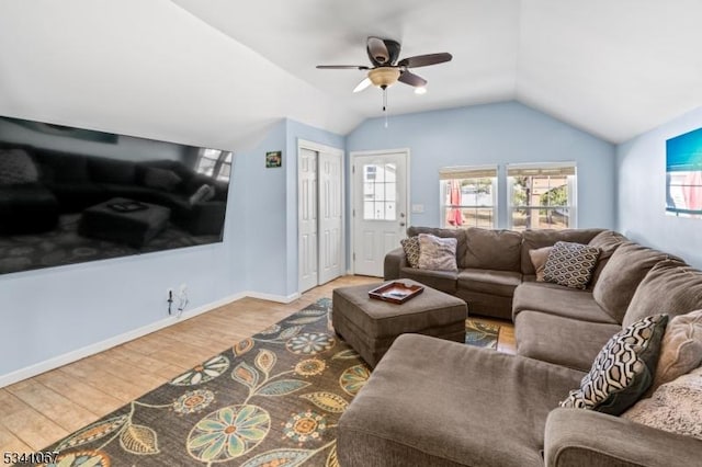 living area with lofted ceiling, ceiling fan, wood finished floors, and a wealth of natural light