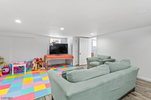 living room featuring baseboards, wood finished floors, and recessed lighting