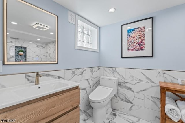 full bathroom featuring toilet, marble finish floor, vanity, and recessed lighting