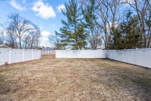 view of yard with an outdoor structure and a fenced backyard