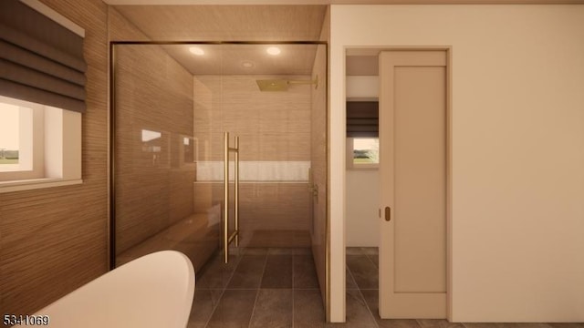 bathroom featuring toilet, tiled shower, and tile patterned floors