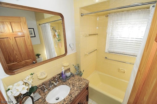 bathroom with tile walls, vanity, and shower / bathtub combination with curtain