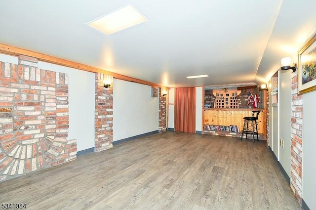 unfurnished room with a dry bar and wood finished floors