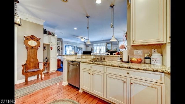 kitchen with pendant lighting, light wood-style flooring, a sink, dishwasher, and a peninsula