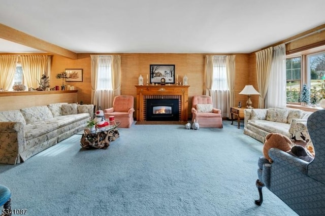 carpeted living room with a wealth of natural light, a brick fireplace, and beamed ceiling