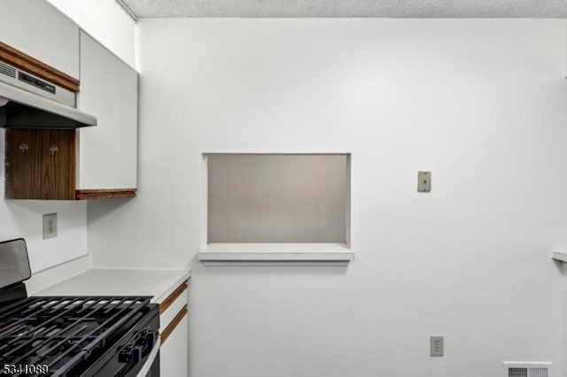 kitchen with visible vents, light countertops, gas range, and under cabinet range hood