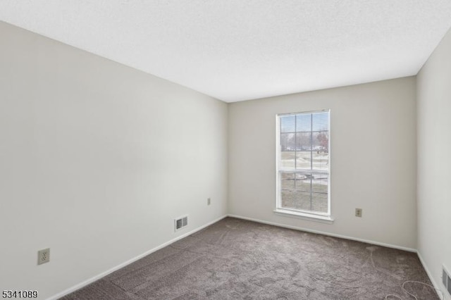 unfurnished room featuring baseboards, visible vents, and carpet flooring