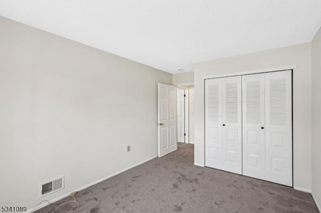 unfurnished bedroom with a closet, baseboards, visible vents, and carpet flooring