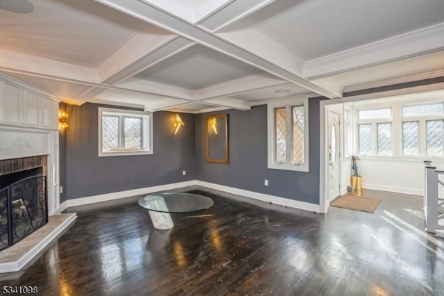 living area with baseboards, coffered ceiling, wood finished floors, a brick fireplace, and beam ceiling