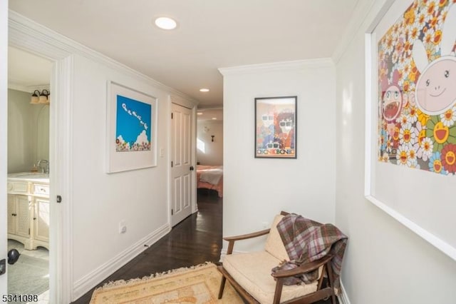 hallway featuring crown molding, recessed lighting, a sink, wood finished floors, and baseboards