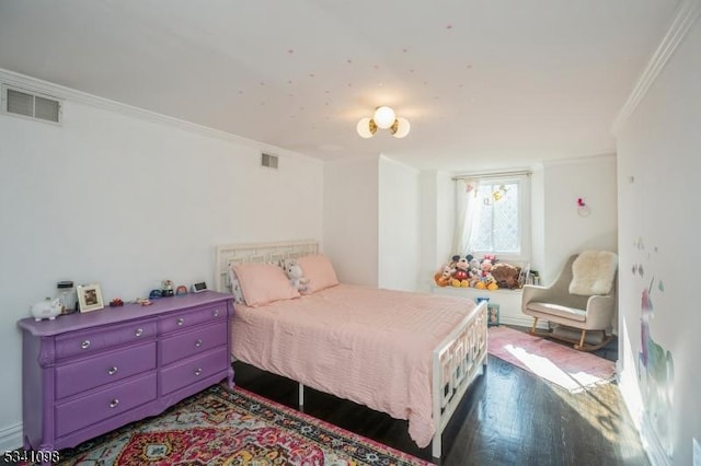 bedroom featuring dark wood finished floors, visible vents, and crown molding