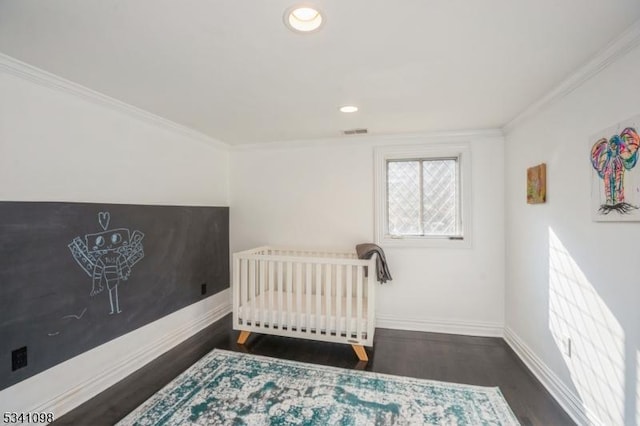 bedroom with baseboards, wood finished floors, and crown molding