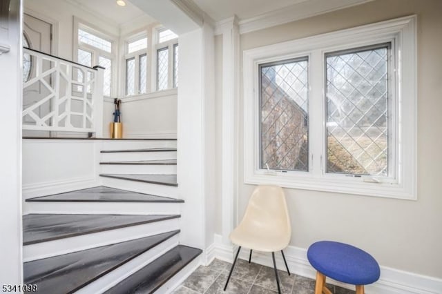 staircase featuring baseboards and crown molding