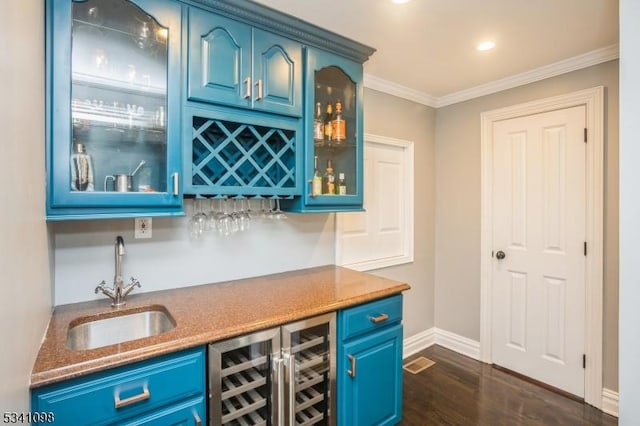 bar featuring wine cooler, a sink, ornamental molding, wet bar, and dark wood finished floors