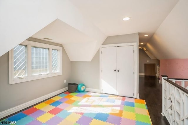 recreation room with dark wood-style flooring, recessed lighting, visible vents, vaulted ceiling, and baseboards