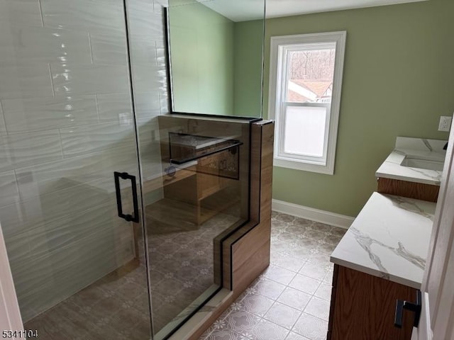 bathroom with vanity, baseboards, a stall shower, and tile patterned flooring