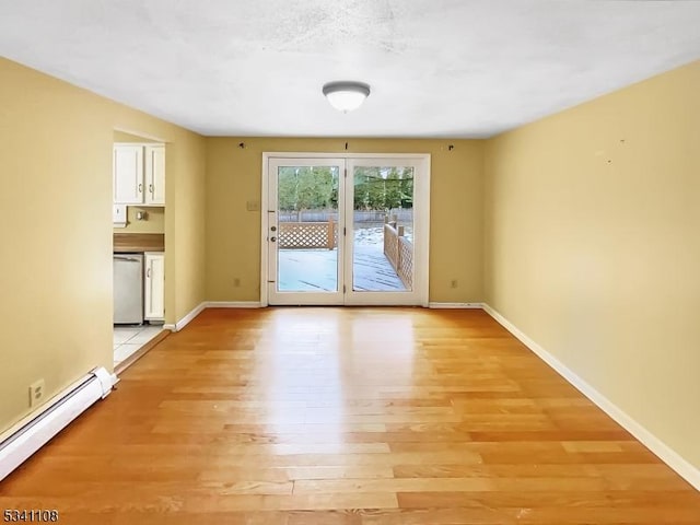 empty room with baseboards, light wood-style flooring, and baseboard heating