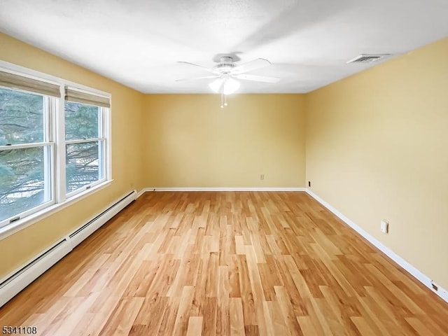 empty room featuring light wood finished floors, a baseboard radiator, visible vents, a ceiling fan, and baseboards