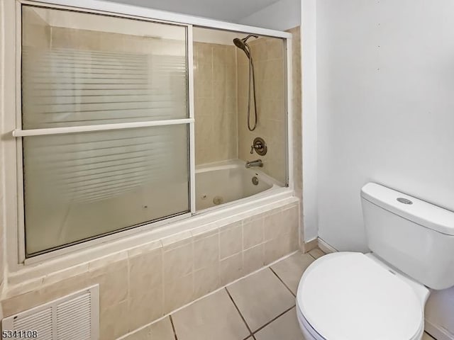 bathroom featuring toilet, tile patterned flooring, visible vents, and tiled shower / bath