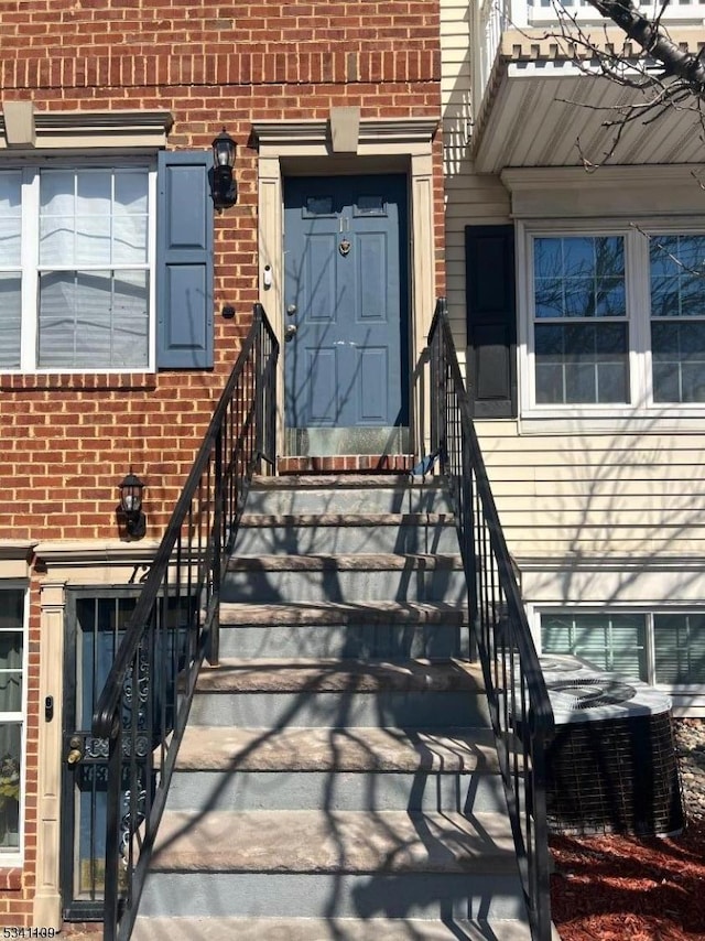 entrance to property with brick siding and central AC unit