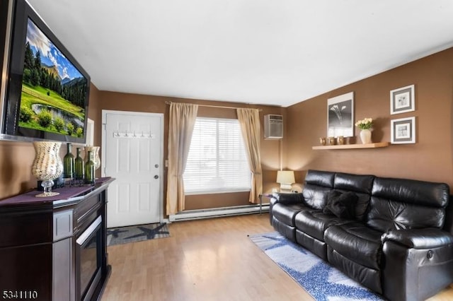 living room with a glass covered fireplace, an AC wall unit, light wood finished floors, and baseboard heating