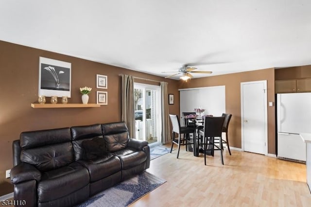 living area with light wood finished floors and a ceiling fan