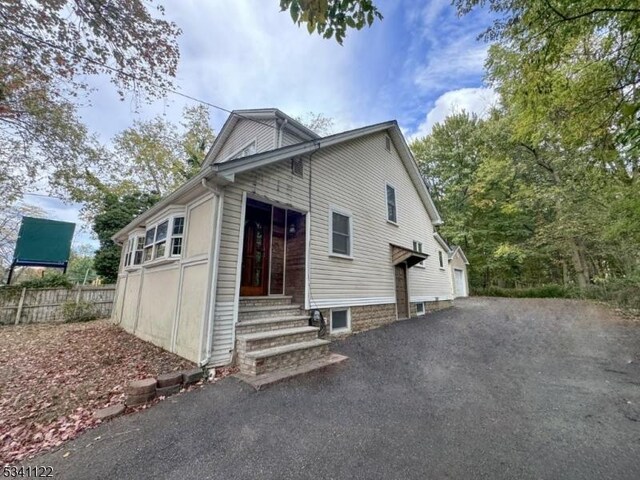 view of home's exterior featuring entry steps and fence