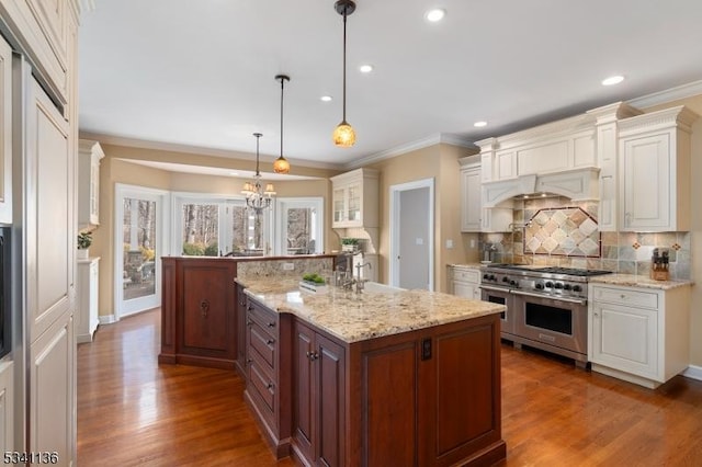 kitchen with ornamental molding, range with two ovens, and white cabinets