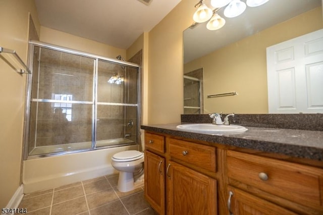 full bathroom featuring tile patterned flooring, toilet, vanity, and shower / bath combination with glass door