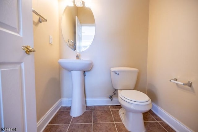 bathroom featuring tile patterned flooring, toilet, and baseboards