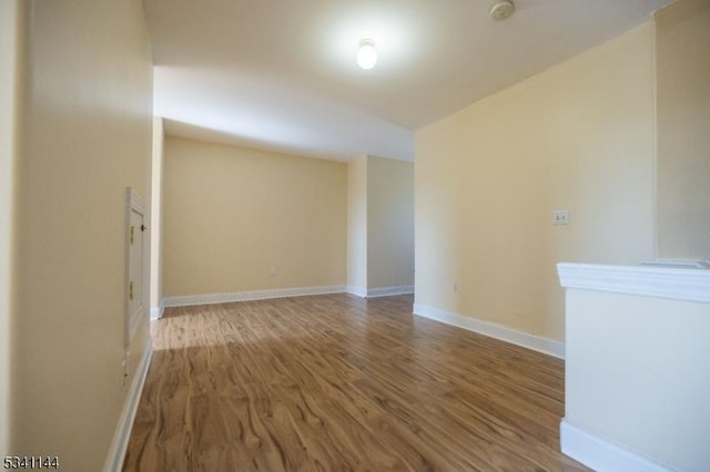 spare room with wood finished floors and baseboards