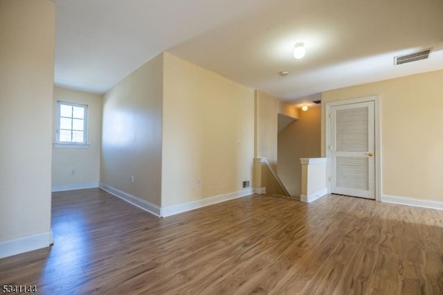 empty room featuring visible vents, baseboards, and wood finished floors