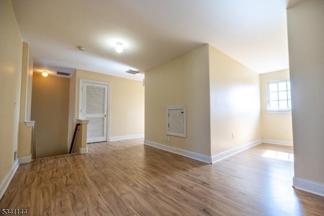 unfurnished room featuring visible vents, baseboards, and wood finished floors