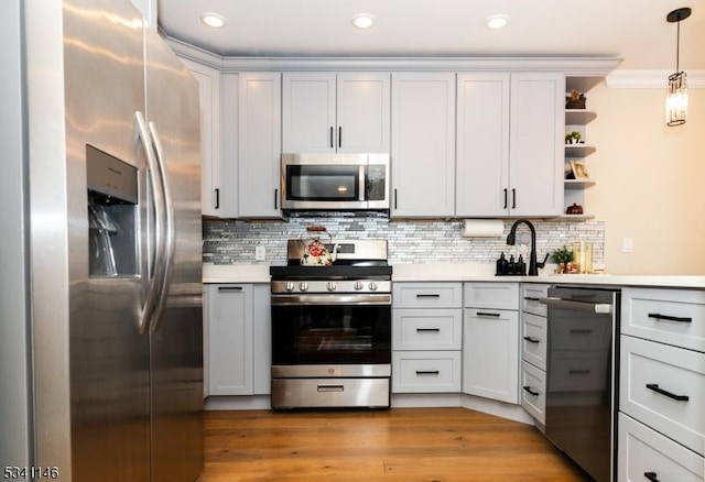 kitchen with appliances with stainless steel finishes, light countertops, backsplash, and open shelves