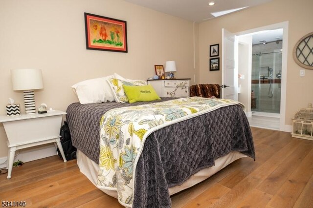 bedroom with recessed lighting, wood finished floors, and baseboards