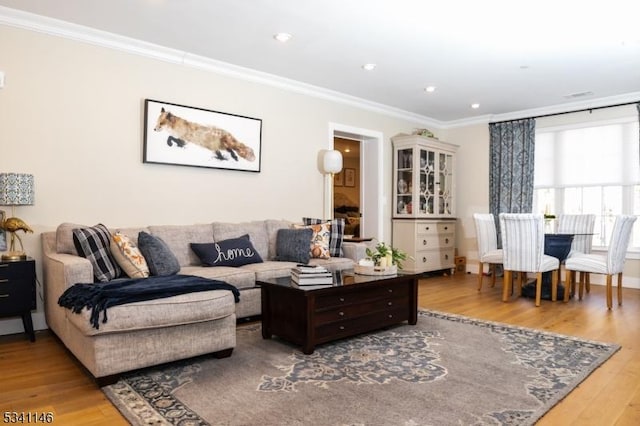 living area with crown molding, wood finished floors, and recessed lighting