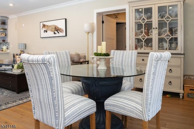 dining area featuring ornamental molding and wood finished floors