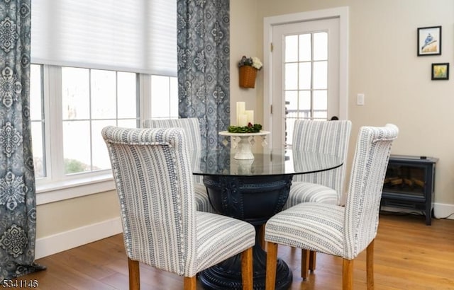 dining area with baseboards and wood finished floors