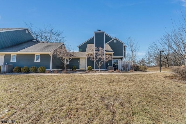 rear view of property with a lawn, a chimney, and cooling unit