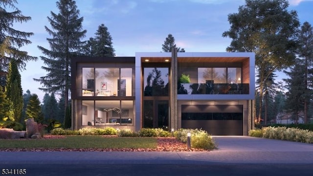 modern home with concrete driveway, a balcony, and an attached garage