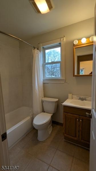 bathroom featuring toilet, shower / bath combination with curtain, vanity, and tile patterned flooring